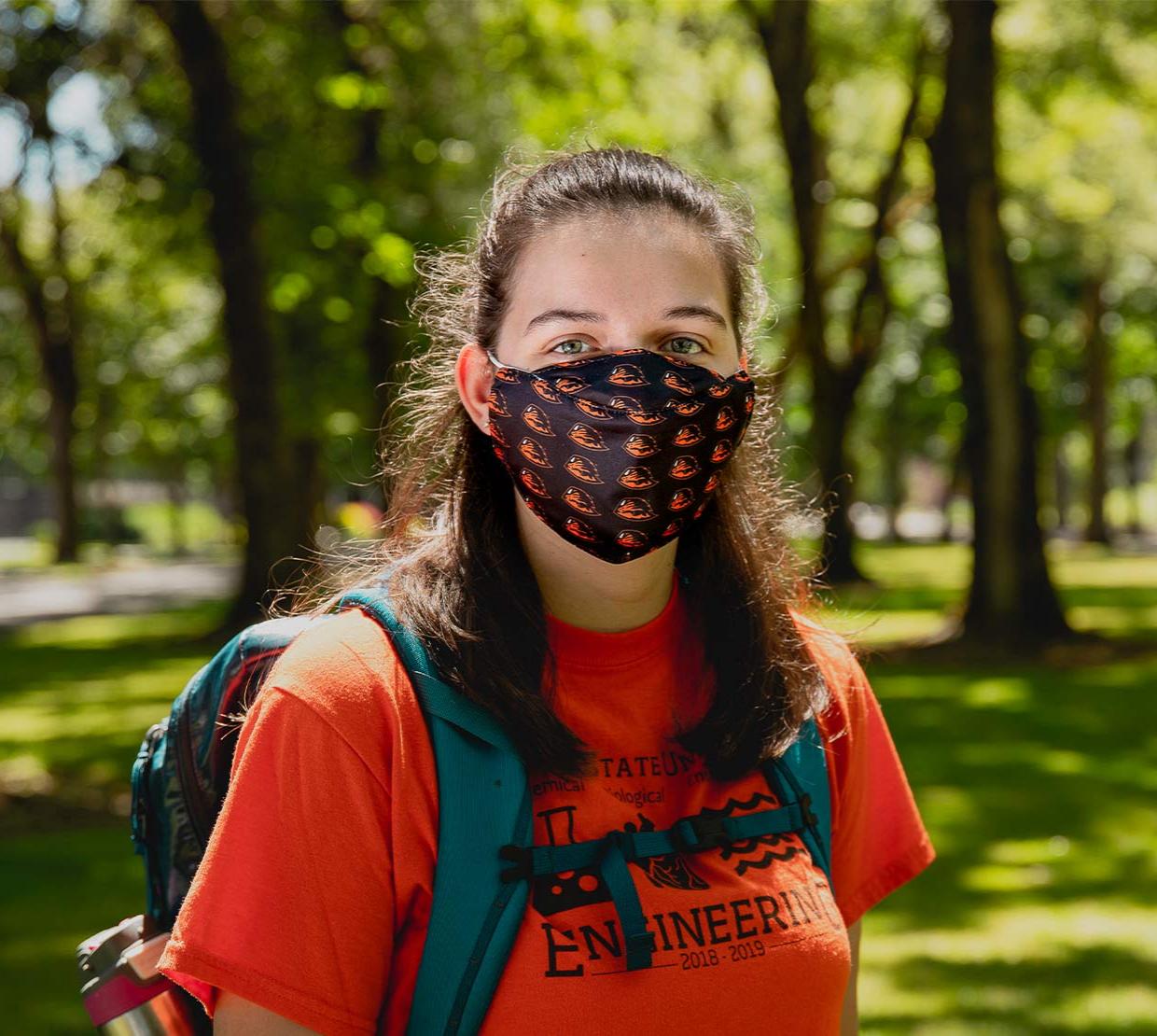 OSU student wearing face mask in a field on OSU Corvallis campus.