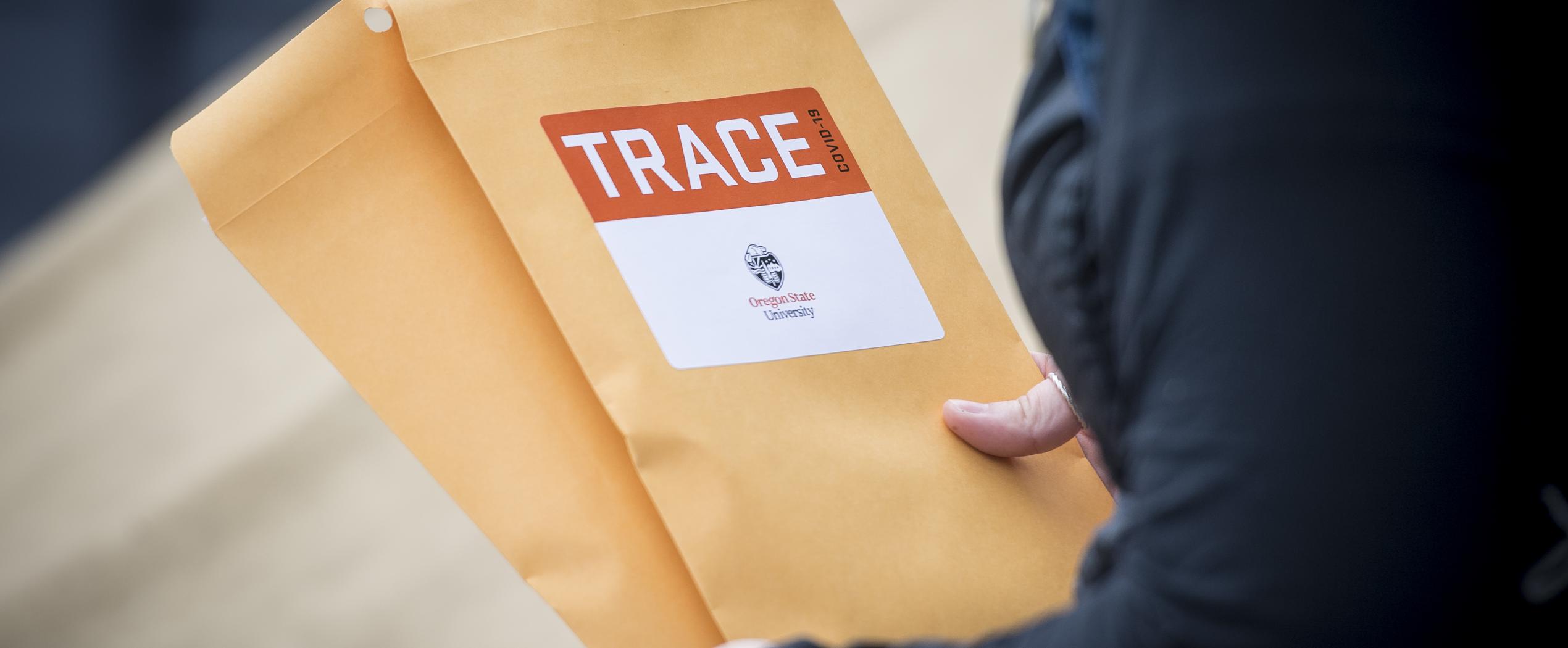 A TRACE volunteer holds envelopes