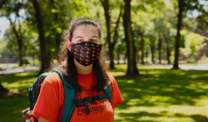 OSU student wearing face mask in a field on OSU Corvallis campus.